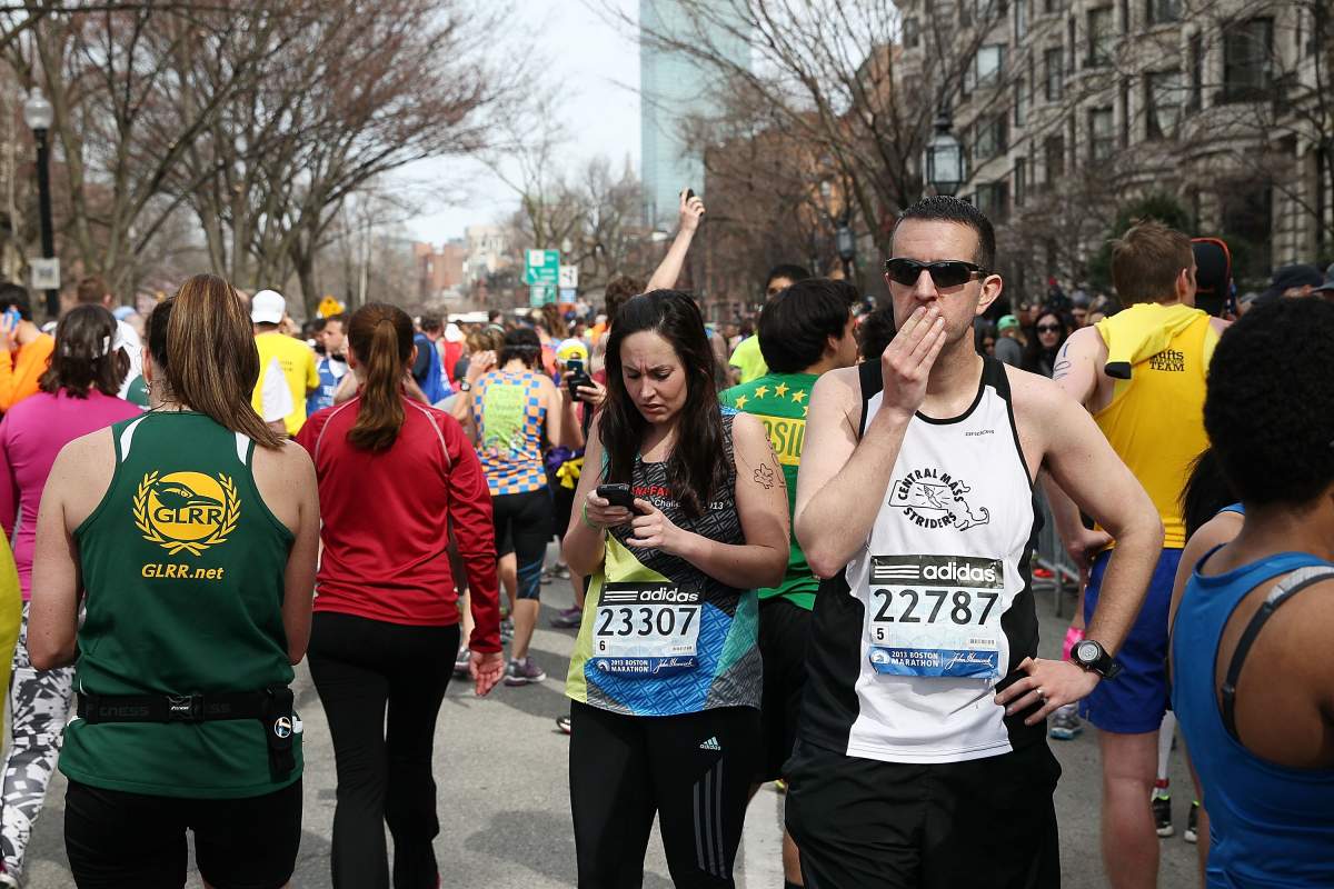 Runners react near Kenmore Square after two bombs exploded during the 117th Boston Marathon on April 15, 2013 in Boston, Massachusetts. 