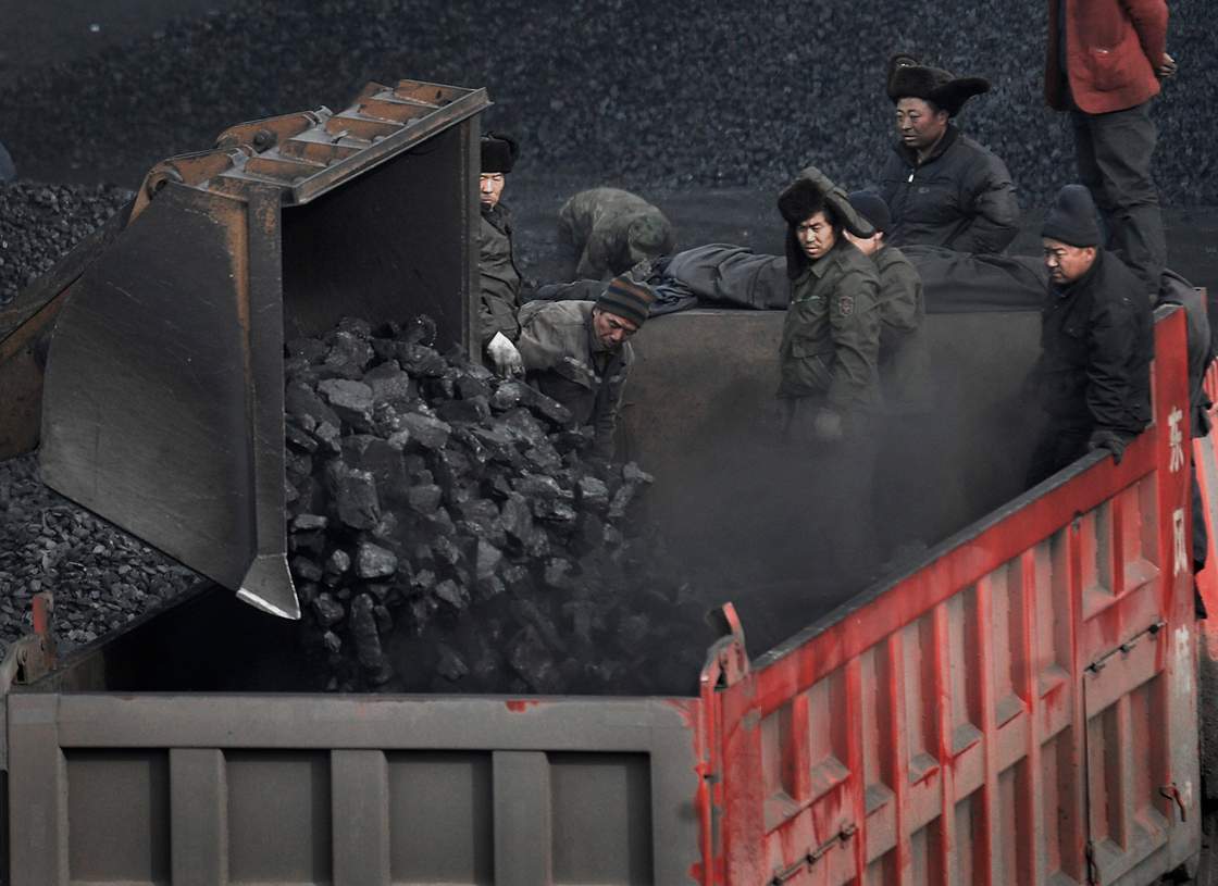 FILE - In this Dec. 3, 2009 file photo, workers load coal into a truck outside a coal mine in Dadong, Shanxi province, China. 