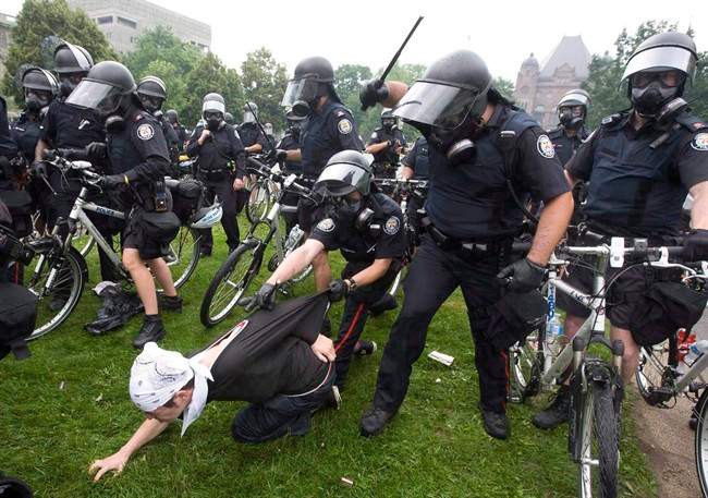 Police club an activist during the G20 Summit in Toronto, June 26, 2010. 
