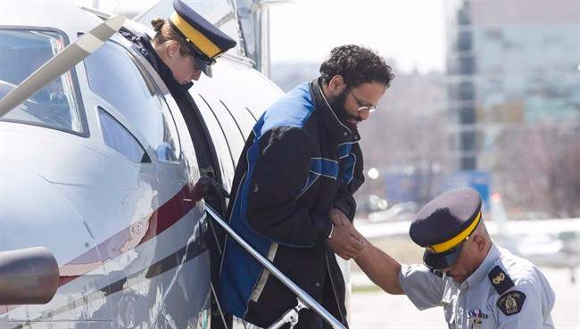 Chiheb Esseghaier is led off a plane by RCMP officers at Buttonville Airport on April 23, 2013. THE CANADIAN PRESS/Chris Young.