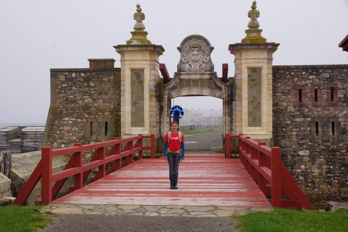 A Google Canada employee wearing the Trekker stands on the Dauphin Gate at the Fortress of Louisbourg.