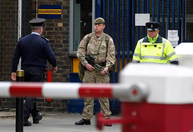 An armed soldier stands guard at the gate of the Royal Artillery Barracks near the scene of a terror attack in Woolwich, southeast London, Thursday, May 23, 2013. Police remained at the scene throughout the night after a brutal attack in a London street Wednesday, which left one member of the armed forces dead and two injured, and the two attackers were also hospitalised. The British government Cabinet's emergency committee immediately called a meeting and Prime Minister David Cameron's office said security was stepped up at barracks across London. 