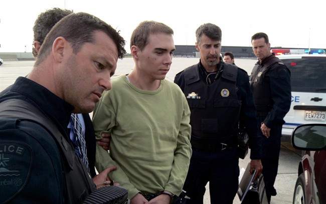 Police escort Luka Magnotta from a military plane to a waiting van in Mirabel, Que., in this Monday, June 18, 2012 file photo provided by Montreal Police. T