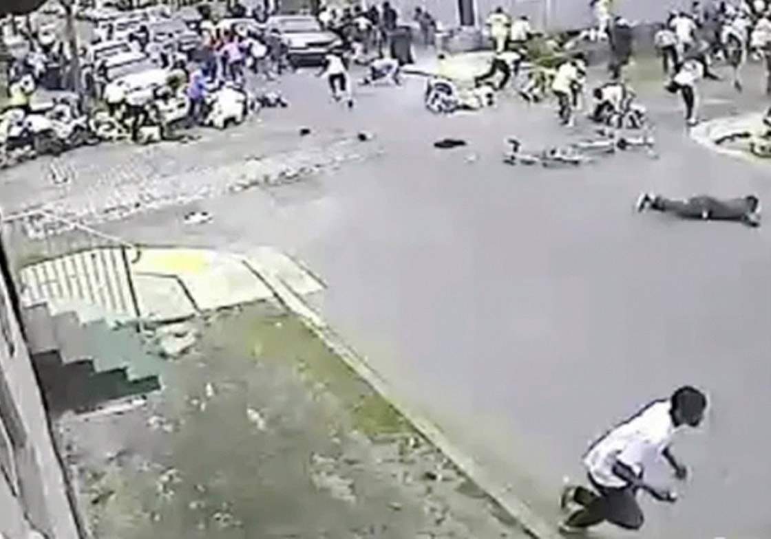 In this image taken from video and provided Monday, May 13, 2013, by the New Orleans Police Department, a possible shooting suspect in a white shirt, bottom center, shoots into a crowd of people, Sunday in New Orleans. Police believe more than one gun was fired in the Mother’s Day gunfire that wounded 19 people during a New Orleans neighborhood parade. (AP Photo/New Orleans Police Department)