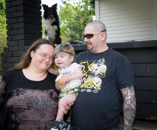Kaiba Gionfriddo is hugged by his parents April and Bryan outside their Youngstown, Ohio home Tuesday, May 21, 2013. Born with a birth defect that caused the boy to stop breathing every day, he can now breathe normally, with a first-of-a-kind biodegradable airway made by Michigan doctors using plastic particles and a 3-D laser printer.