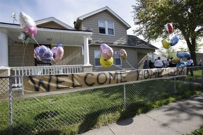 A "Welcome Home Gina " sign hangs on a fence outside the home of Gina DeJesus Tuesday, May 7, 2013, in Cleveland.