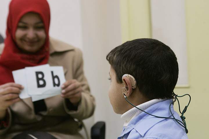 A woman health worker assesses a boy at Atfaluna Society for Deaf Children, a local NGO in the Rimal area of Gaza, in the Occupied Palestinian Territories, the largest city in the Gaza Strip (Photo credit: UNICEF).