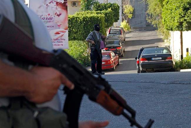 File: Gunmen and followers of a radical Sunni cleric Sheik Ahmad al-Assir block a road, in the southern port city of Sidon, Lebanon, Tuesday, June 18, 2013.