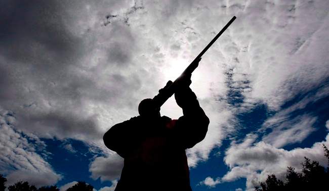 A rifle owner checks the sight of his rifle at a hunting camp west of Ottawa, Sept. 15, 2010.