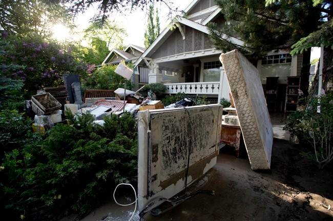 Mud-covered furniture is seen on the front lawn of a home near the Elbow River in Calgary, Alta., Saturday, June 22, 2013. 
