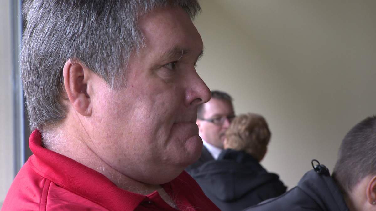 James Moore waits outside Nova Scotia Supreme Court to testify that MLA Trevor Zinck (background) never gave his son a promised $860 to cover hockey league fees.