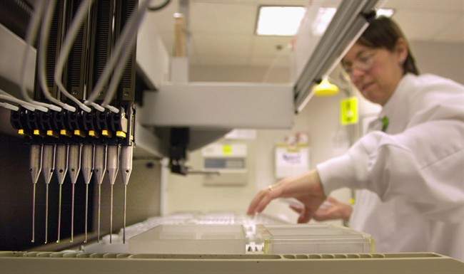 FILE - A technician loads patient samples into a machine for testing at Myriad Genetics Friday, May 31, 2002, in Salt Lake City. 