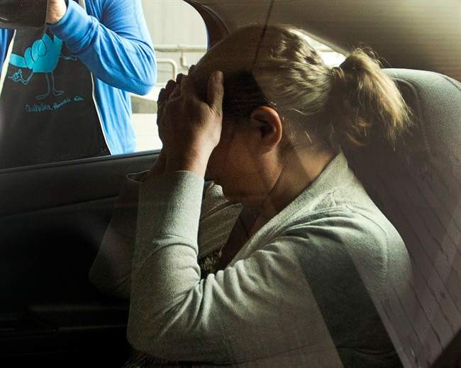 Pamela Mattock Porter, wife of Arthur Porter, hides from the cameras as she is brought to the courthouse to be arraigned on money laundering charges Friday, June 14, 2013 in Montreal.THE CANADIAN PRESS/Ryan Remiorz.