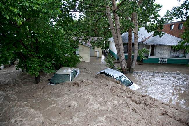 Submerged cars sits in the flood waters in High River, Alta. on June 20, 2013.
