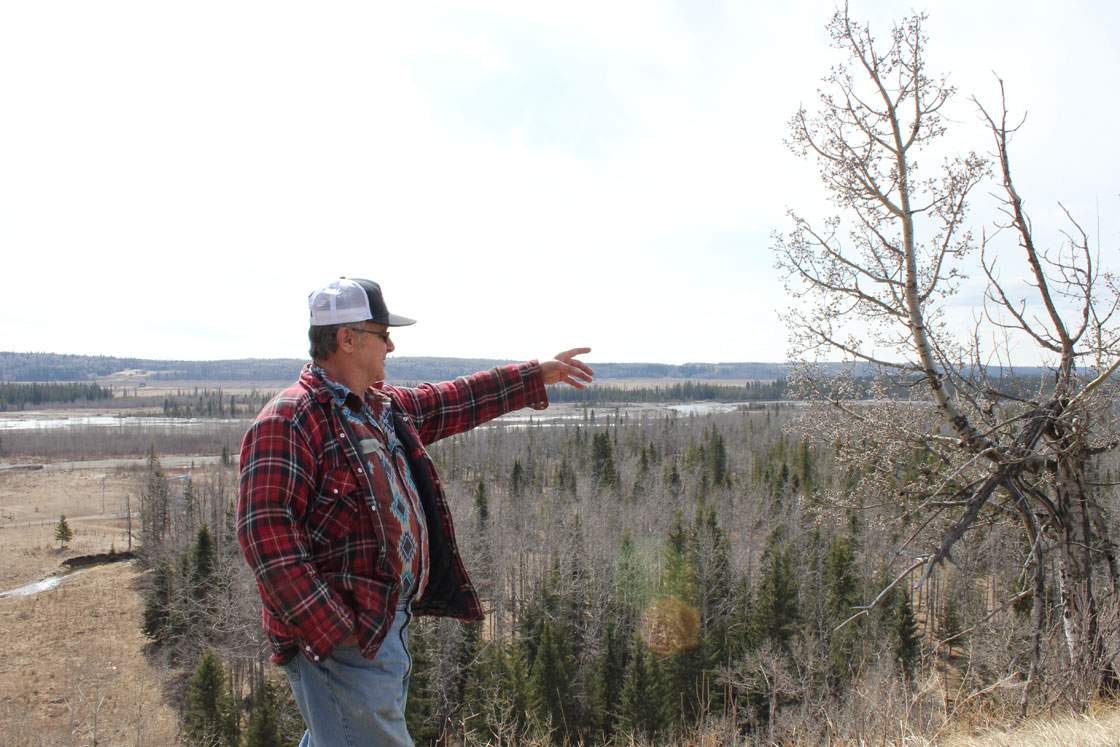 Wayne Johnston points to the riverbank.