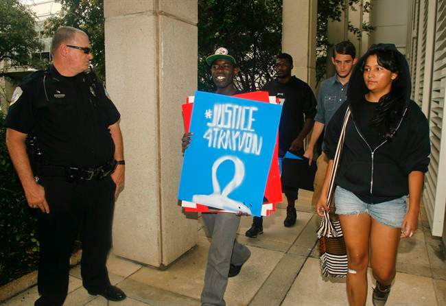 A Capitol police officer watches as protestors walk by him Tuesday July 16, 2013 at the Capitol in Tallahassee, Fla.