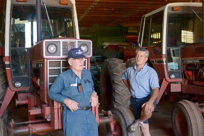 Brian Best, right, and his father David stand in the barn housing their tractors Saturday July 20, 2013 that normally should be out in the fields working, but because of money problems are stored in the barn. Best and his son Brian run the family farm that has run into debt and to try to keep the farm going they have turned to crowdfunding on the internet. 