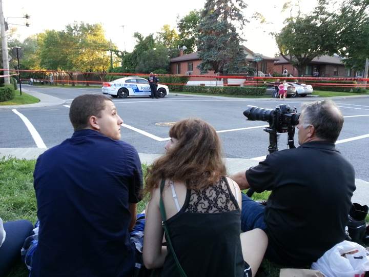 Residents and media outside the perimeter set up by Montreal police in Cote St. Luc on July 30, 2013.