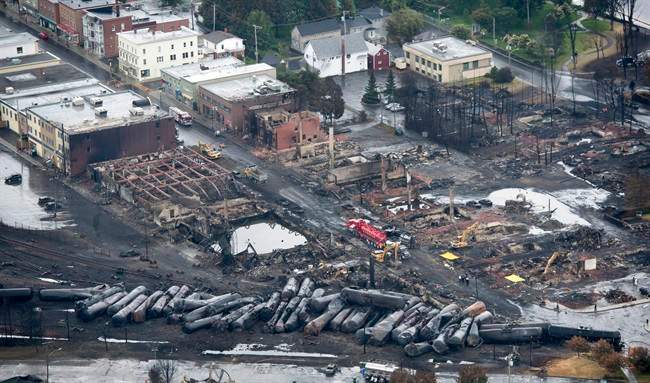 Workers comb through the debris after a train derailed causing explosions of railway cars carrying crude oil Tuesday, July 9, 2013 in Lac-Megantic, Quebec. THE CANADIAN PRESS/Paul Chiasson.