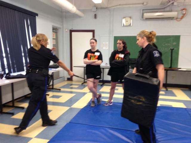 A police officer demonstrates proper use of a baton to the campers.