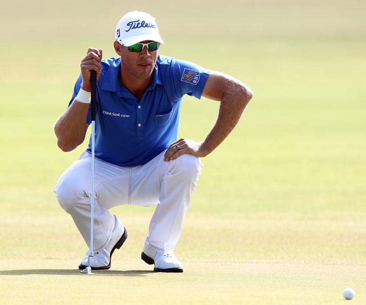 Canada’s Graham DeLaet lines up a putt on the first green during the third round of the 2013 British Open Golf Championship at Muirfield golf course at Gullane in Scotland on July 20, 2013. (Photo credit: PETER MUHLY/AFP/Getty Images)
