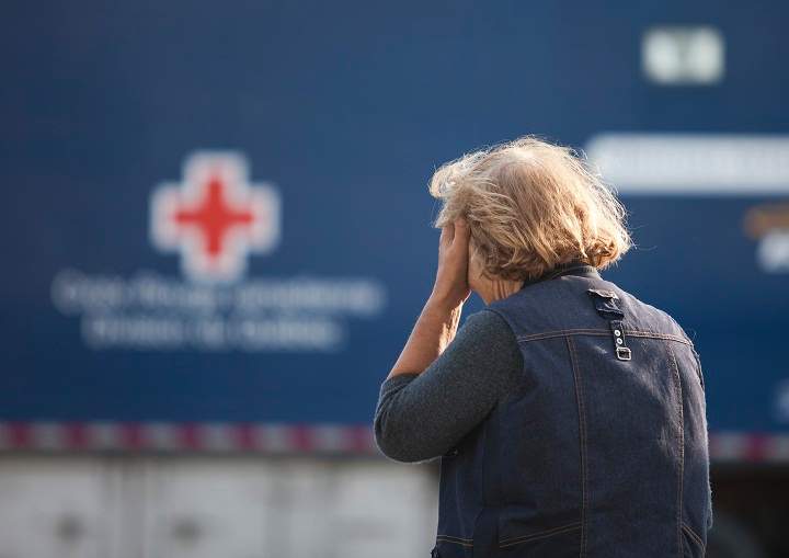A concerned resident waits July 7, 2013 near an aid station set up after a freight train loaded with oil derailed in Lac-Megantic in Canada's Quebec province, sparking explosions that engulfed about 30 buildings in a wall of fire. 