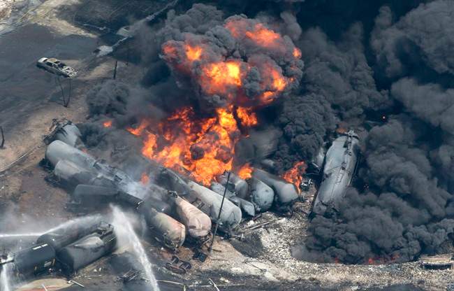 Smoke rises from railway cars that were carrying crude oil after derailing in downtown Lac Megantic, Que., Saturday, July 6, 2013.