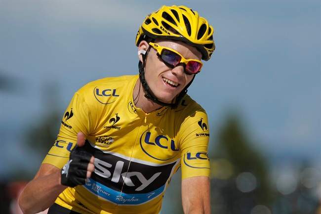 Christopher Froome of Britain, wearing the overall leader's yellow jersey, flashes a thumbs up and a big smile as crosses the finish of the 20th stage of the Tour de France cycling race.