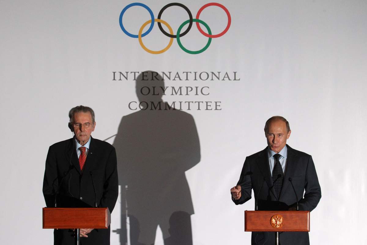 Russian President Vladimir Putin (R) speaks as International Olympic Committee (IOC) President Jacques Rogge listens during a presentation of the medals that will be awarded at the 2014 Winter Olympics in Sochi May 2013 in Saint Petersburg, Russia.  Sasha Mordovets/Getty Images.