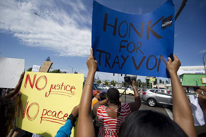 A police helicopter flies overhead as Americans angry at the acquittal of George Zimmerman in the death of black teen Trayvon Martin protest in Los Angeles, California July 14, 2013. (Getty Images)