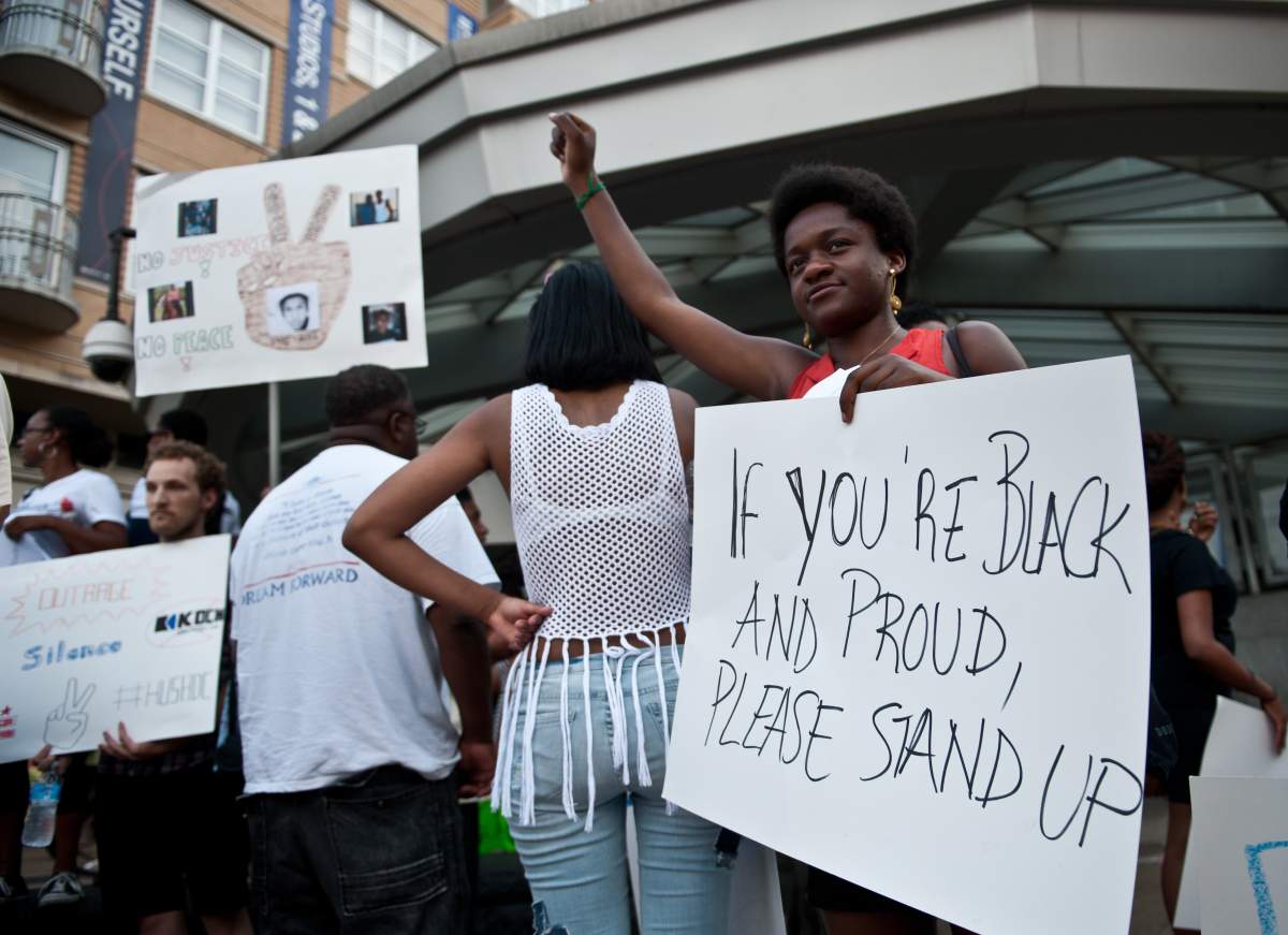 A woman holds a sign in Washington on July 19, 2013 during a demonstration against the acquittal of George Zimmermann in the killing of unarmed Florida teen Trayvon Martin.