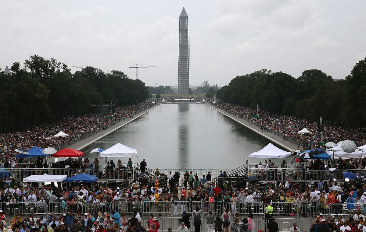 People listen as US President Barack Obama speaks at the Lincoln Memorial on the National Mall August 28, 2013 in Washington, DC. Obama and others spoke to commemorate the 50th anniversary of the US civil rights era March on Washington where Martin Luther King Jr. delivered his ‘I Have a Dream Speech’.