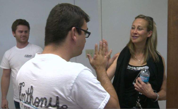 Anthony Barrett gives Julie Brown a high-five as his aide Mikey Hamm looks on.