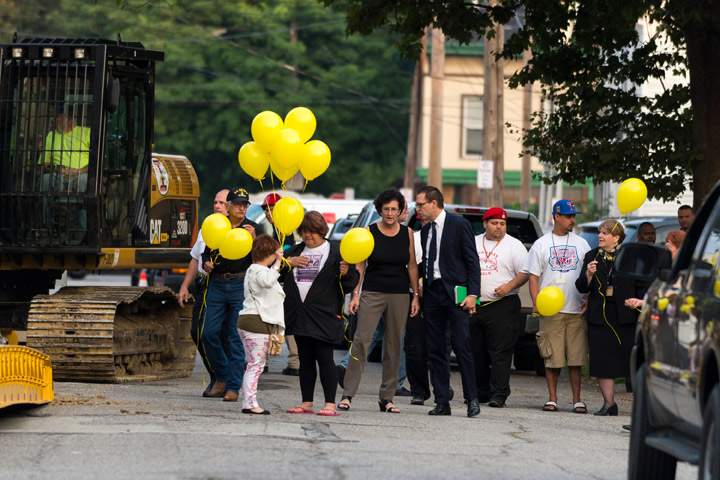 In this photo, Michelle Knight (L3) holds yellow balloons outside the home of Ariel Castro on August 7, 2013 in Cleveland, Ohio. (Photo credit: Getty Images)