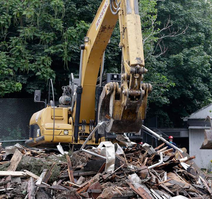 The house where three women were held captive and raped for more than a decade is demolished, Wednesday, Aug. 7, 2013, in Cleveland. (Photo credit: AP Photo)