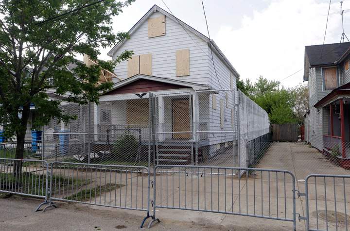 In this file photo, a 10-foot chain link fence surrounds the home of Ariel Castro in Cleveland on May 14, 2013. (Photo credit: AP Photo/File)