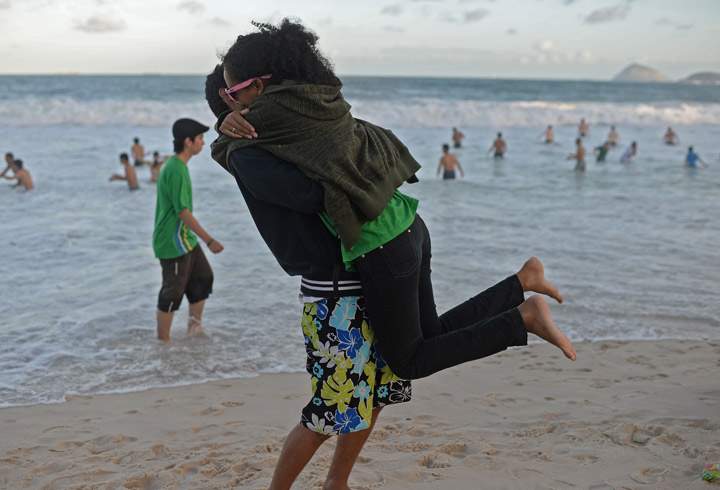 Young Catholic pilgrims attending World Youth Day embrace as they wait for the arrival of Pope Francis for a prayer vigil at Copacabana beach in Rio de Janeiro, on July 27, 2013. (Photo credit: Getty Images)