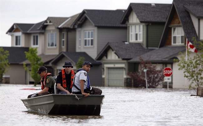 Members of the RCMP return from a boat patrol of a still flooded neighborhood in High River, Alta., July 4, 2013.