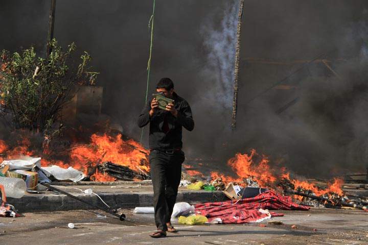 A protester carries copies of the Quran as the Egyptian security forces clear a sit-in by supporters of ousted Islamist President Mohammed Morsi in the eastern Nasr City district of Cairo, Egypt, Wednesday, Aug. 14, 2013. Ahmed Gomaa / AP Photo