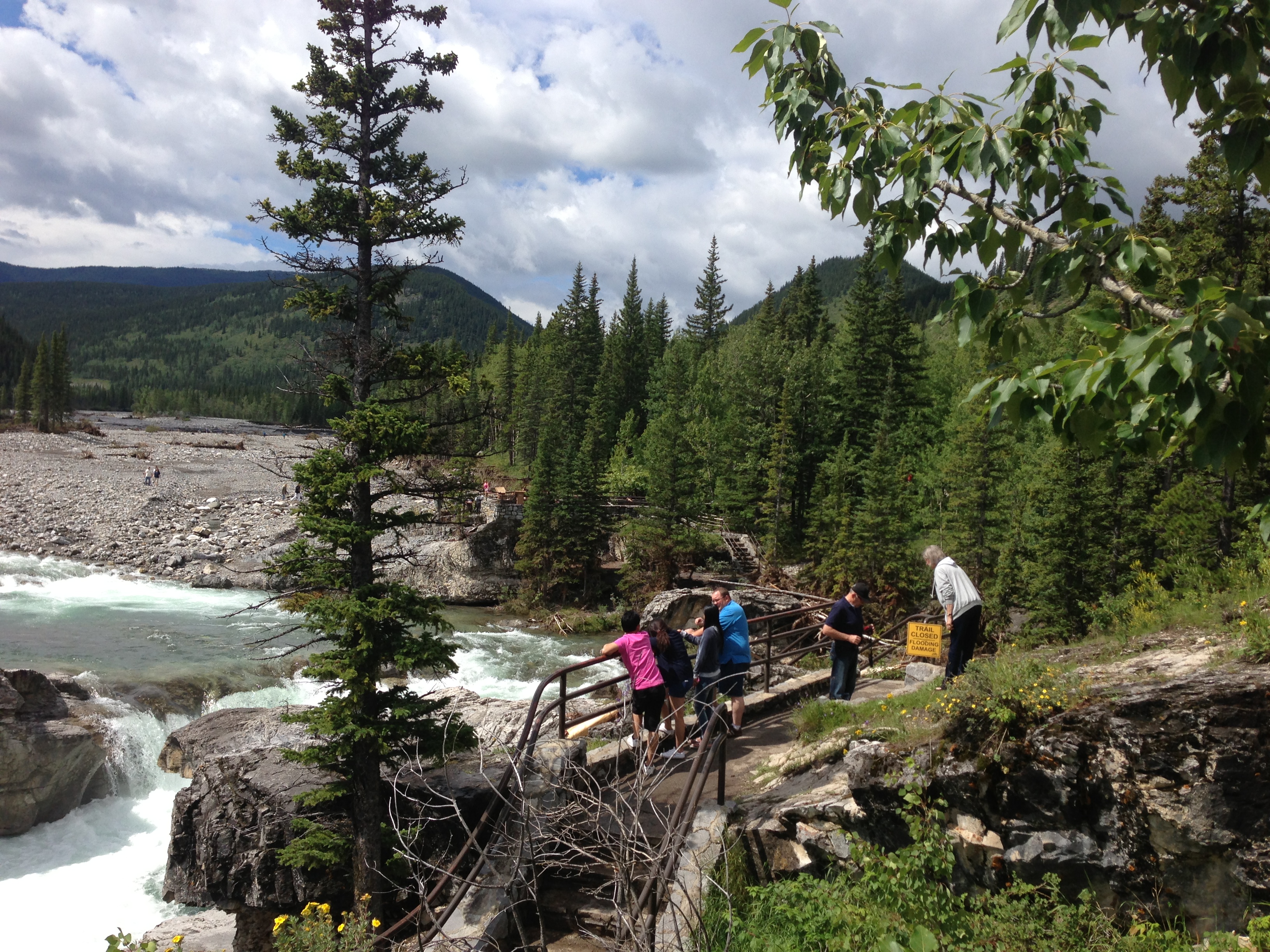 Tourists scan Elbow Falls following the 2013 floods, taking in the dramatic change to the popular attraction.