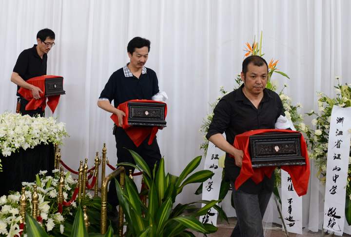 The fathers of Asiana plane crash victims Liu Yipeng, Wang Linjia and Ye Mengyuan carry the ashes of their daughters during a memorial service at Jiangshan Municipal Funeral Home on August 1, 2013 in Jiangshan, China (Photo credit: Getty Images). Read the latest here.