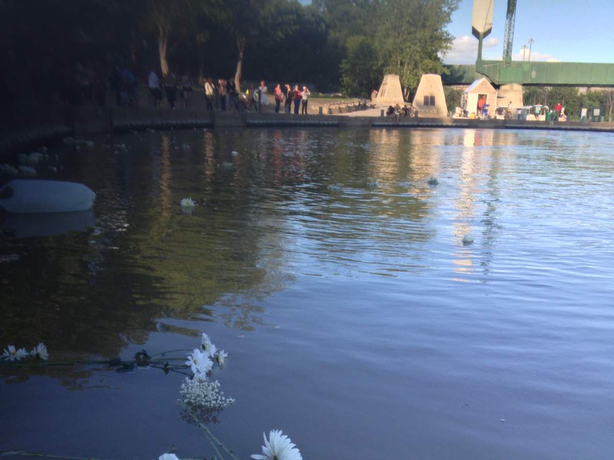 People who attended Thursday’s vigil were asked to bring white flowers, which were dropped into the Assiniboine River.