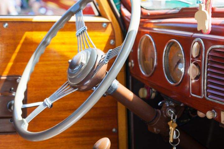 Steering wheel and dashboard of a vintage car.