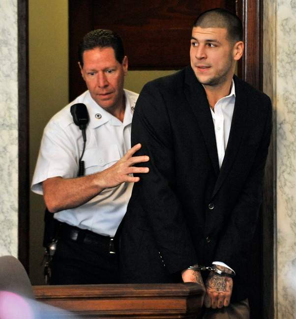 Former New England Patriot football player Aaron Hernandez, is lead into court in Attleboro, Mass., Thursday, Aug. 22, 2013. 