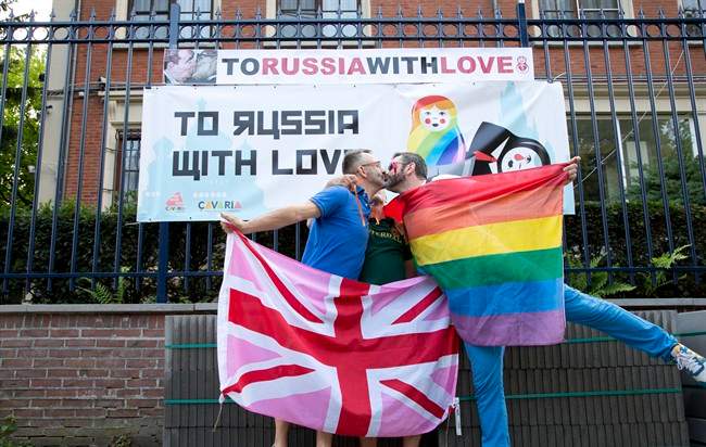Two men take part in a kiss-in in front of the Russian Consulate in Antwerp, Belgium on Friday, Aug. 9, 2013. 