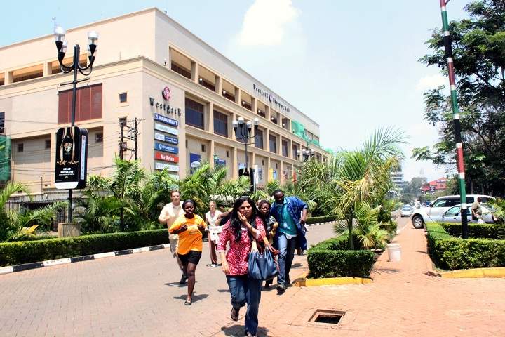 People run from the Westgate Mall in Nairobi, Kenya on Saturday Sept. 21 2013, after gunmen threw grenades and opened fire during an attack. (AP Photo/Jason Straziuso).