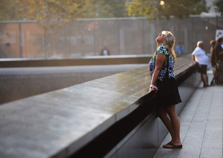 Michelle Murray of Rockaway, New Jersey looks up while standing at the 9/11 Memorial during ceremonies for the twelfth anniversary of the terrorist attacks on lower Manhattan at the World Trade Center site on September 11, 2013 in New York City. (Photo credit: Getty Images)
