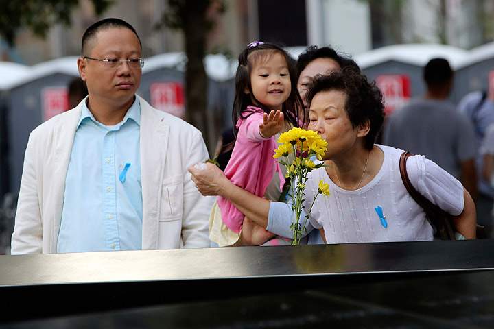 Family members of Ji Yao Justin Zhao pay their respect to him at the South Pool of the 9/11 Memorial during ceremonies for the twelfth anniversary of the terrorist attacks on lower Manhattan at the World Trade Center site on September 11, 2013 in New York City. (Photo credit: AP Photo)