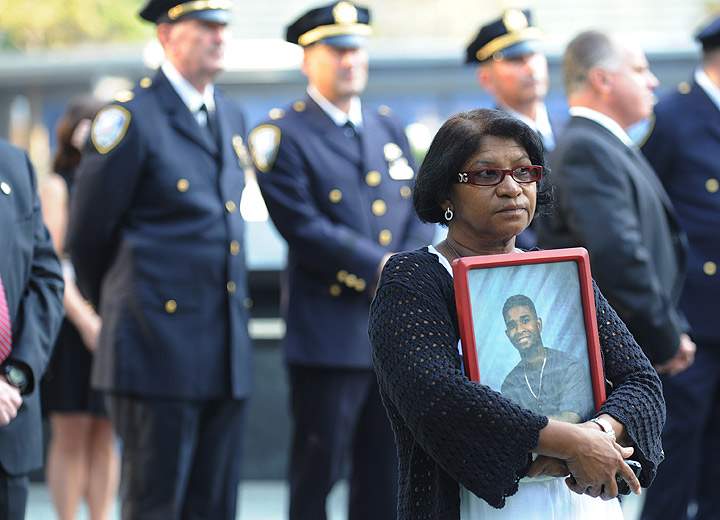 A woman holds a picture at the 9/11 Memorial during ceremonies for the twelfth anniversary of the terrorist attacks on lower Manhattan at the World Trade Center site on September 11, 2013 in New York City. (Photo credit: Getty Images)