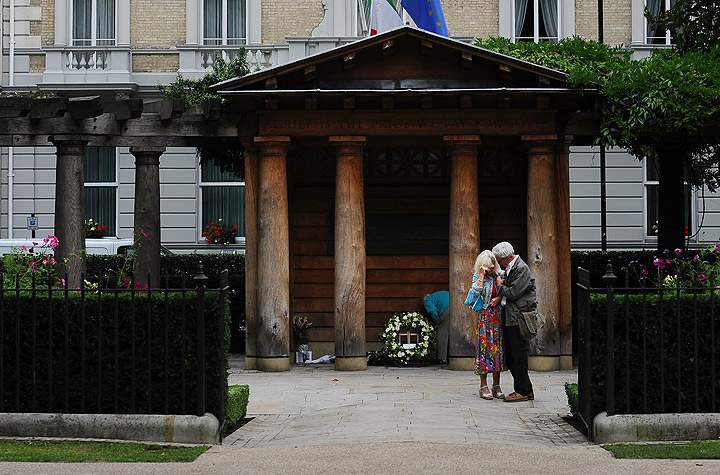 A man comforts a woman at the memorial near the US embassy in central London on September 11, 2013 to mark the anniversary of the 911 attacks on New York, the Pentagon and in Shanksville, Pennsylvania. (Photo credit: Getty Images)